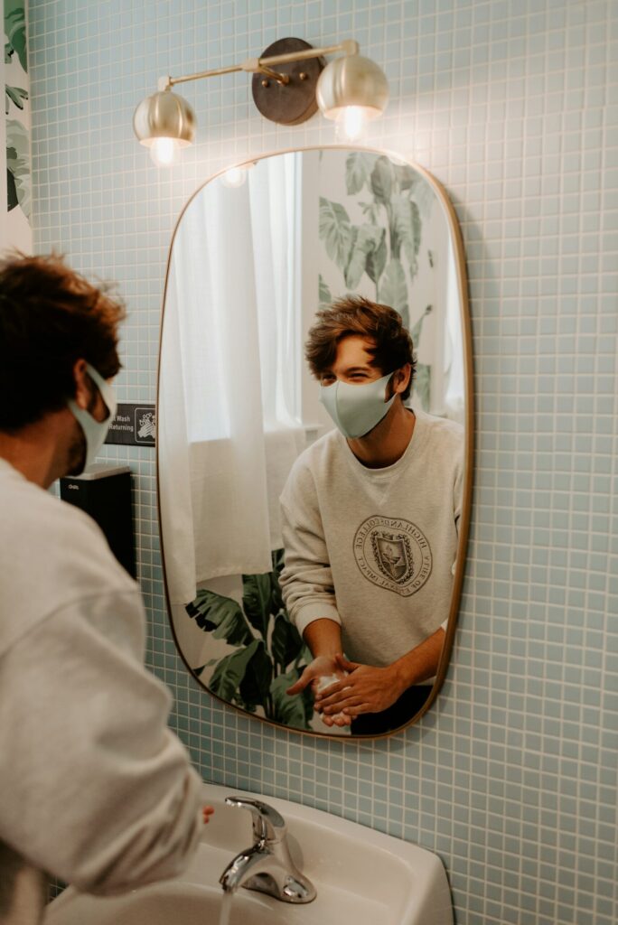 マスクしながら手を洗っている男性のイメージ画像